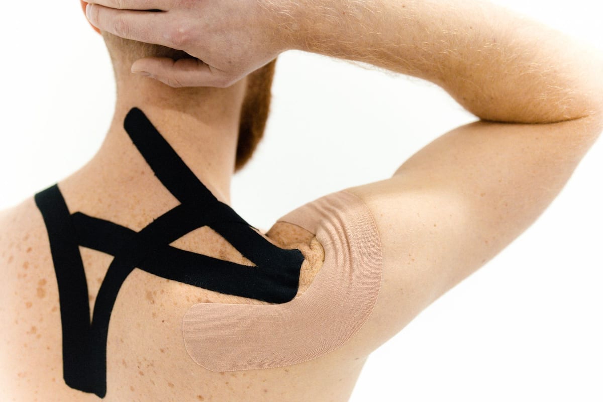 Kinesiology tape applied across a shoulder and neck